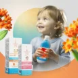An advertisement for Avenos Dermo kids' skincare featuring a happy baby holding a bottle of Sun Protection Cream. The image also displays the boxes for Kids Sensitive Advanced SPF 50+ Sun Cream and Diaper Rash Cream, with the slogan "safety in every drop.